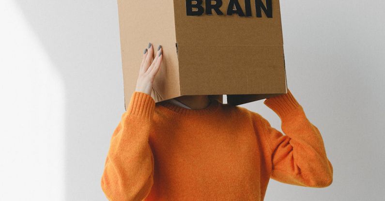 Purpose-Driven - Crop person putting Idea title in cardboard box with Brain inscription on head of female on light background