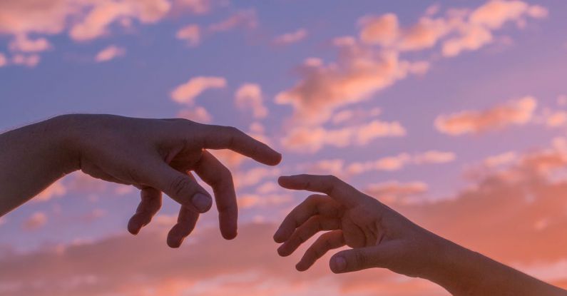 Green Bonds - Crop anonymous people pulling hands to each other against bright sunset sky with clouds