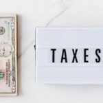 Tax Obligations - American dollar bills and vintage light box with inscription