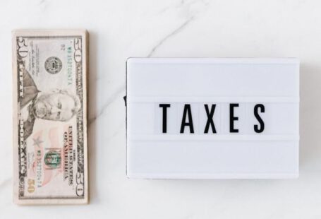 Tax Obligations - American dollar bills and vintage light box with inscription