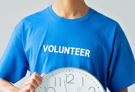 Volunteer Time Off - A Man in Blue Shirt Holding a Clock