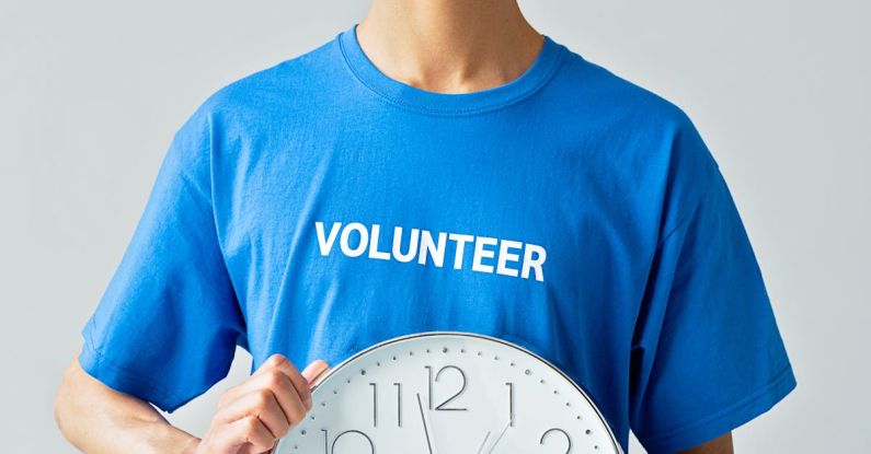 Volunteer Time Off - A Man in Blue Shirt Holding a Clock