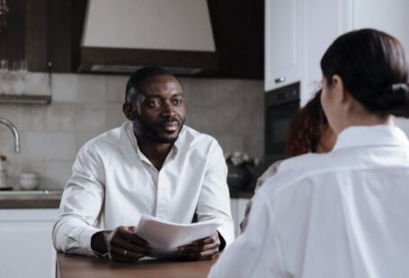 Social Responsibility Program - Afro-American Man and Caucasian Woman Having Meeting at Home with Social Worker