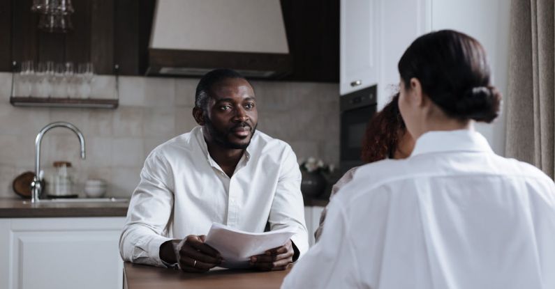 Social Responsibility Program - Afro-American Man and Caucasian Woman Having Meeting at Home with Social Worker